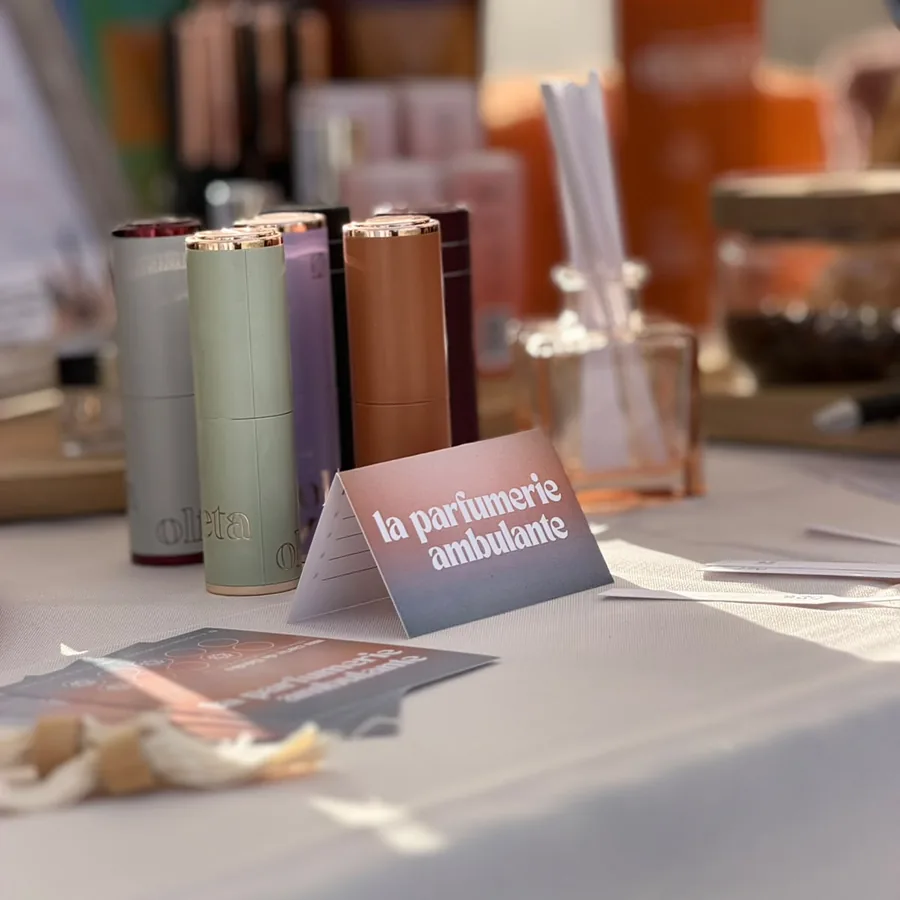 Étuis de parfum de poche colorés et chevalet la parfumerie ambulante sur une nappe blanche