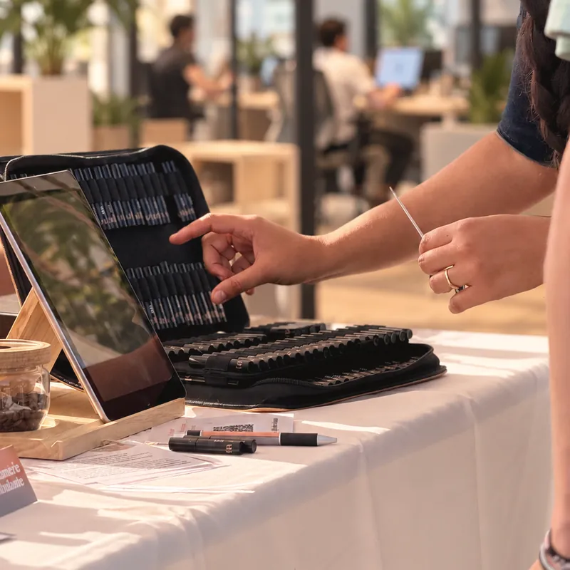 Une collaboratrice choisit un parfum sur la tablette, dans un open space